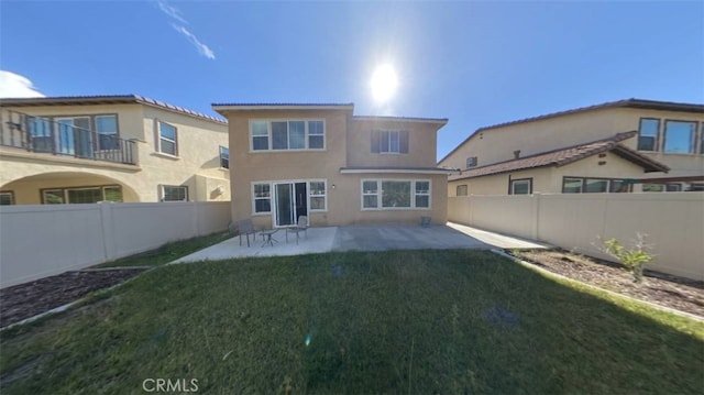 rear view of property with a lawn and a patio