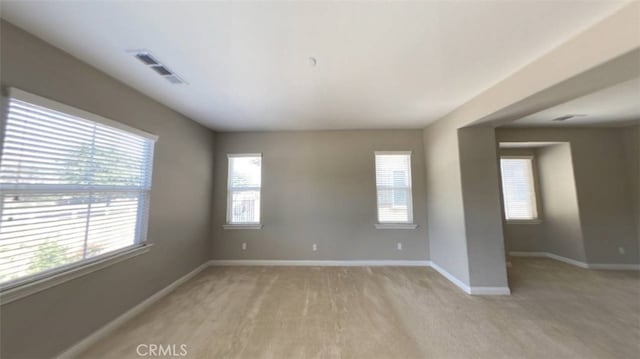 unfurnished room with light wood-type flooring and a wealth of natural light