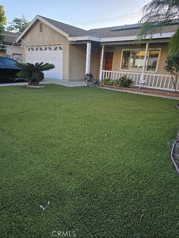 ranch-style home with a porch, a garage, and a front yard