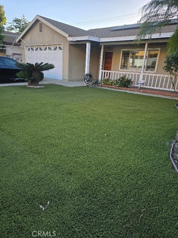 ranch-style house with a porch, a garage, and a front lawn