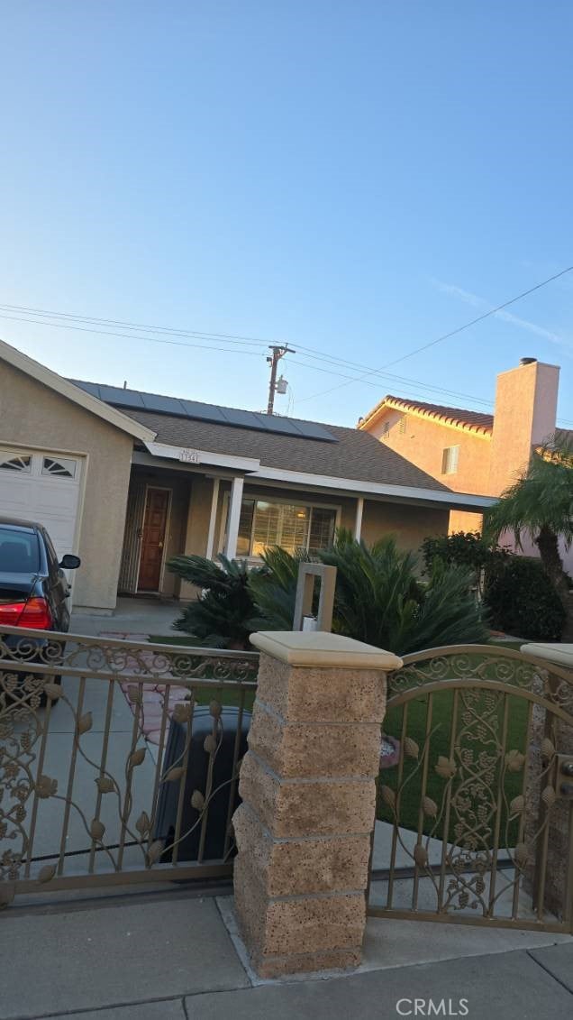 view of front facade with solar panels and a garage