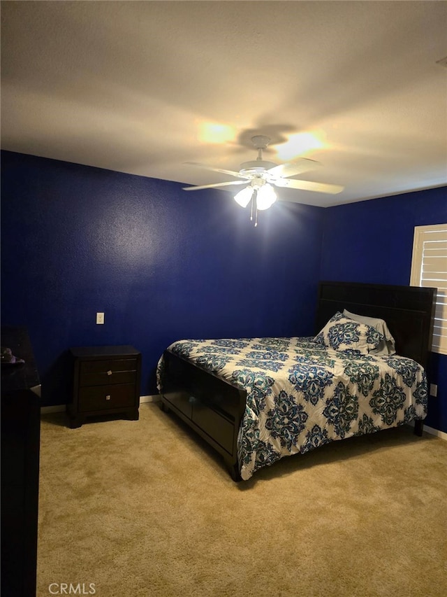 bedroom with ceiling fan and light carpet