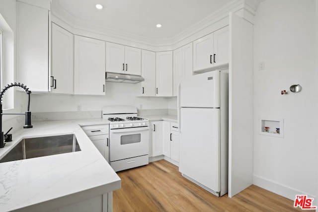 kitchen featuring white appliances, white cabinets, sink, light hardwood / wood-style floors, and light stone counters