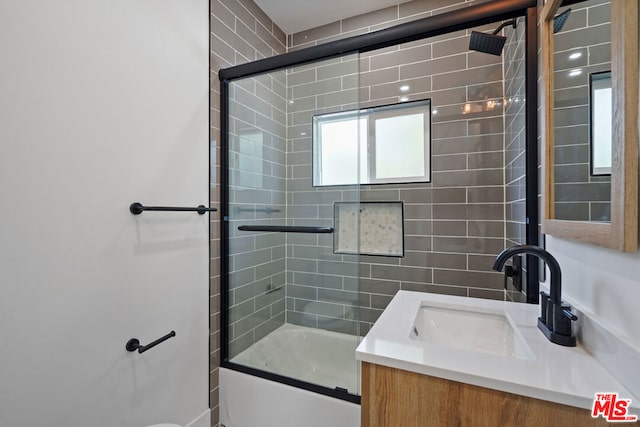 bathroom with vanity and bath / shower combo with glass door