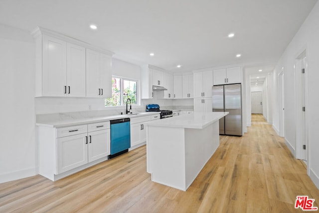 kitchen featuring appliances with stainless steel finishes, light wood-type flooring, white cabinetry, and a kitchen island