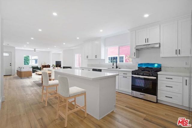 kitchen featuring white cabinets, stainless steel gas stove, and light hardwood / wood-style floors