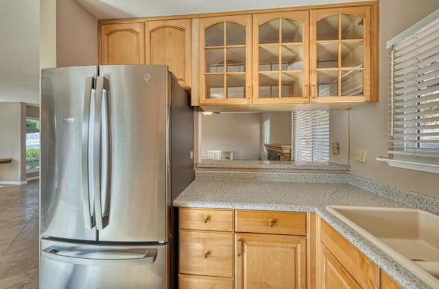 kitchen with sink, light brown cabinets, and stainless steel fridge