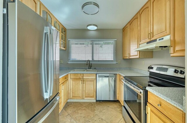 kitchen with light tile patterned floors, sink, light brown cabinets, and stainless steel appliances