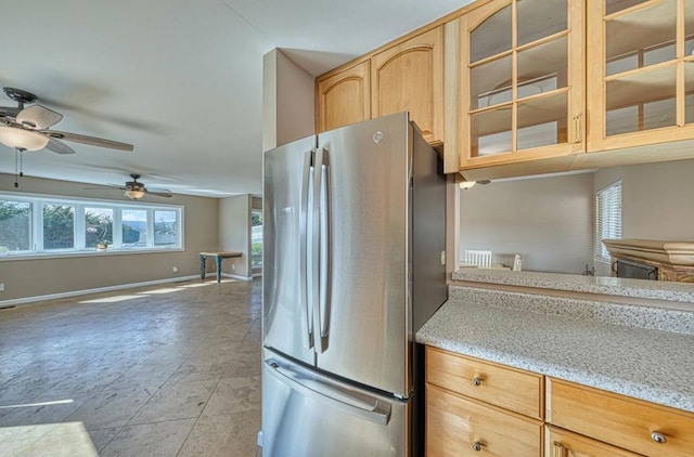 kitchen featuring ceiling fan, a healthy amount of sunlight, light brown cabinetry, and stainless steel refrigerator