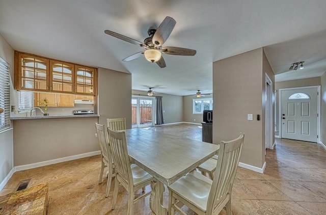 dining room with ceiling fan, light tile patterned floors, and sink