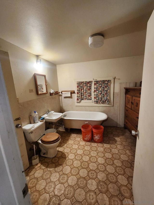 bathroom with toilet and a washtub