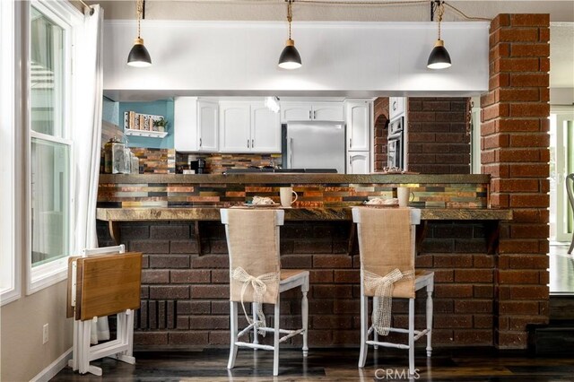 bar with appliances with stainless steel finishes, pendant lighting, white cabinetry, and dark hardwood / wood-style floors