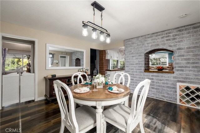 dining room featuring a fireplace, dark hardwood / wood-style floors, and brick wall