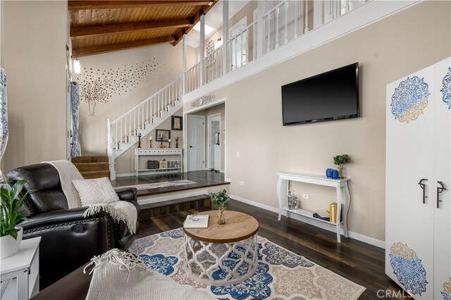 living room featuring beam ceiling, dark hardwood / wood-style flooring, and wood ceiling