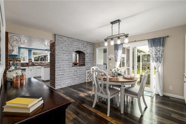 dining area featuring sink, brick wall, and dark hardwood / wood-style floors