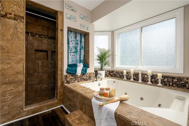 bathroom with hardwood / wood-style floors and separate shower and tub