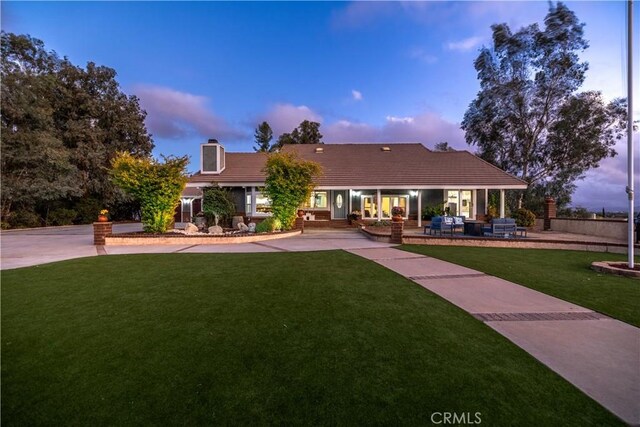 view of front of house featuring a lawn and a patio area