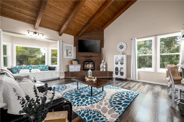 living room featuring a fireplace, beamed ceiling, wood ceiling, and a healthy amount of sunlight