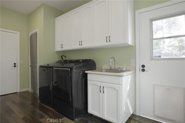 clothes washing area featuring cabinets, sink, dark hardwood / wood-style flooring, and washing machine and clothes dryer