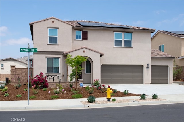 mediterranean / spanish-style home featuring solar panels and a garage