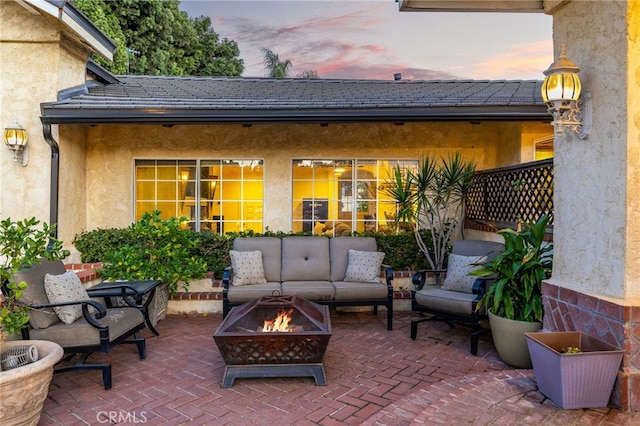 patio terrace at dusk featuring an outdoor living space with a fire pit