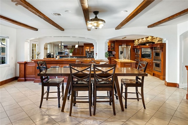 tiled dining space with beamed ceiling