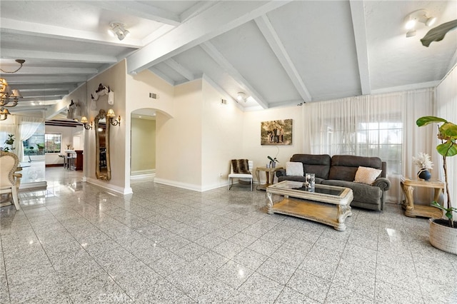 living room with a healthy amount of sunlight, beamed ceiling, high vaulted ceiling, and a chandelier