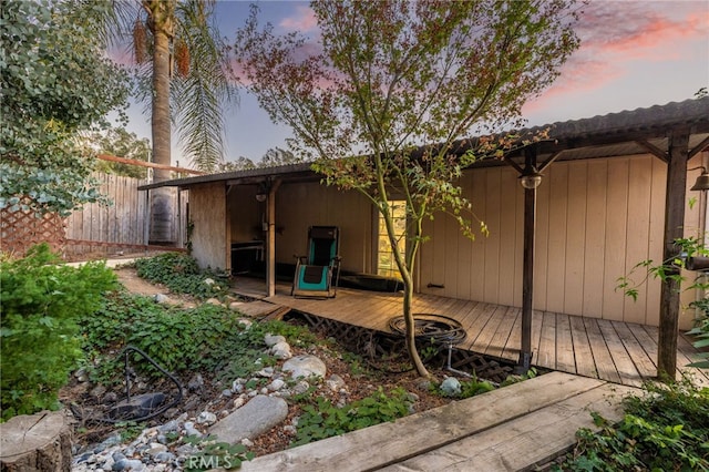 property exterior at dusk featuring a deck