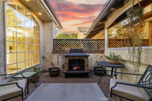 patio terrace at dusk with exterior fireplace