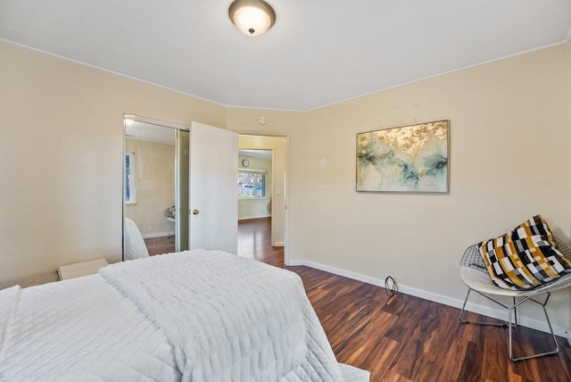 bedroom with ensuite bathroom and dark hardwood / wood-style flooring