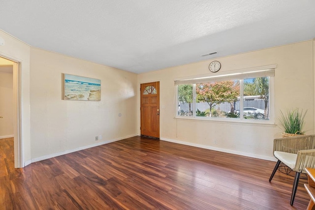 interior space with dark wood-type flooring and a textured ceiling