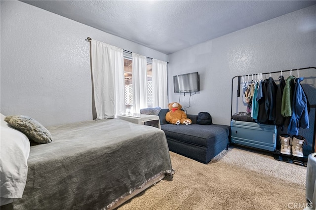 bedroom featuring a textured ceiling and light carpet