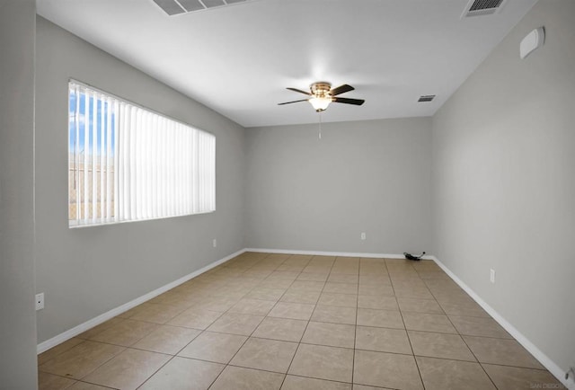 empty room with ceiling fan and light tile patterned flooring