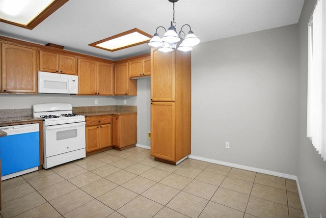 kitchen with light tile patterned floors, decorative light fixtures, white appliances, and a notable chandelier