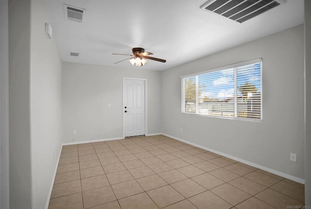 tiled spare room with ceiling fan