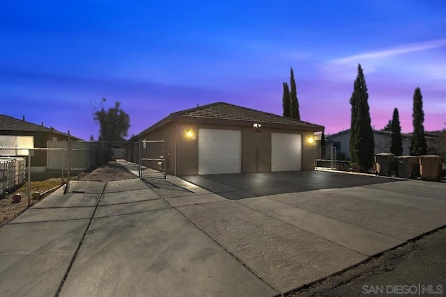 property exterior at dusk with a garage and an outdoor structure