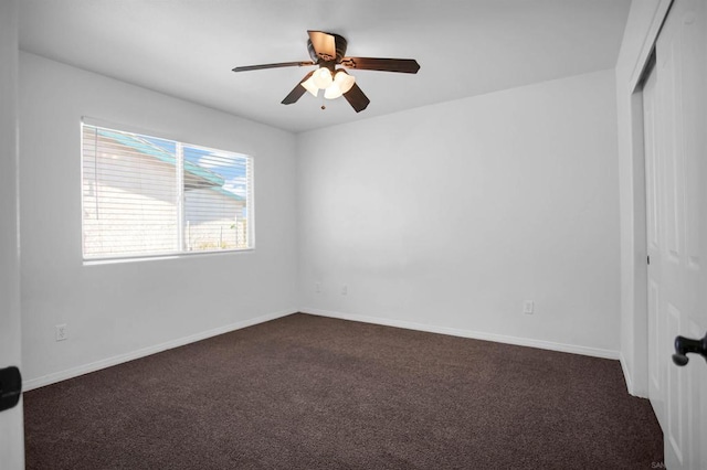 unfurnished room with ceiling fan and dark colored carpet