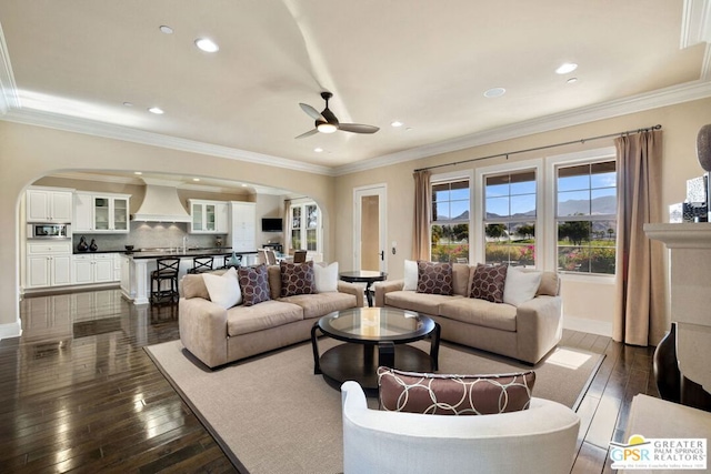 living room with ceiling fan, dark hardwood / wood-style flooring, and crown molding