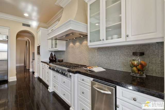 kitchen featuring crown molding, custom range hood, white cabinets, and appliances with stainless steel finishes