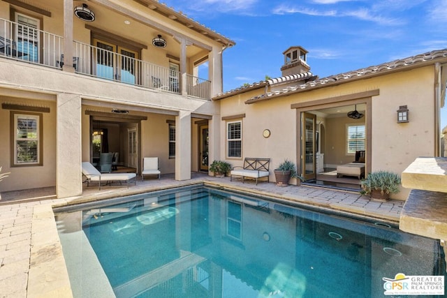 rear view of house featuring a patio and a balcony