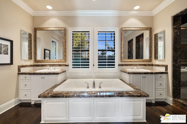 bathroom with ornamental molding, a bath, wood-type flooring, and vanity