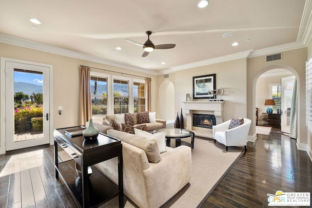 living room with crown molding, dark wood-type flooring, and ceiling fan