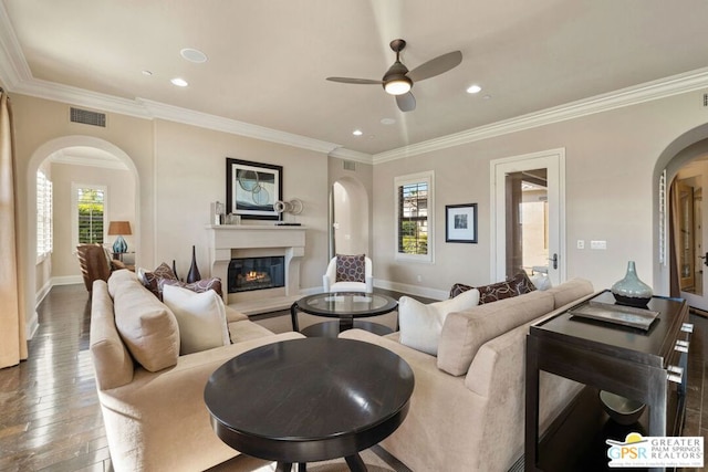 living room with wood-type flooring, ornamental molding, and ceiling fan