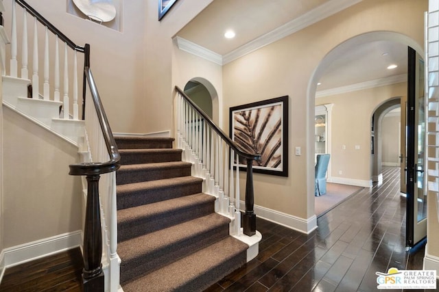 staircase with crown molding and hardwood / wood-style floors