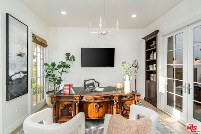 office space featuring a wealth of natural light, french doors, light hardwood / wood-style floors, and an inviting chandelier