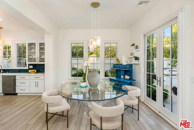 dining space with french doors and light hardwood / wood-style flooring