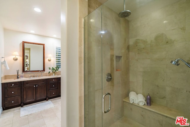 bathroom featuring tile patterned flooring, vanity, and an enclosed shower