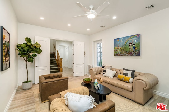 living room featuring light hardwood / wood-style flooring and ceiling fan