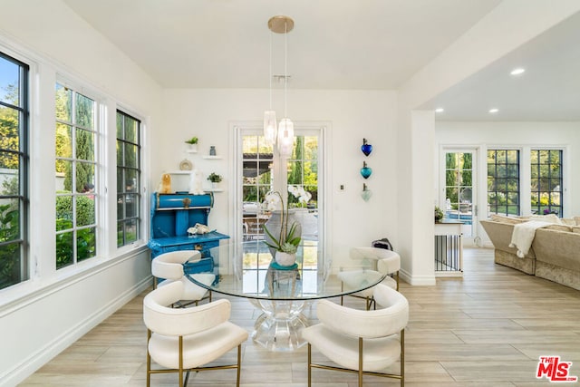 dining space with plenty of natural light, light wood-type flooring, and french doors