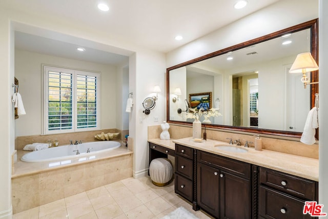 bathroom featuring vanity, tile patterned floors, and tiled tub